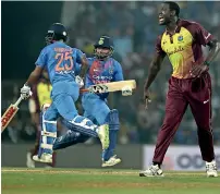  ?? AFP ?? Carlos Barthwaite (right) reacts as Rishabh Pant (centre) and Shikhar Dhawan run between the wickets. —