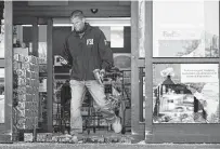  ?? Mark Humphrey / Associated Press ?? An FBI agent steps through the damaged entrance Friday of a Kroger, the scene of a mass shooting in Colliervil­le, Tenn.