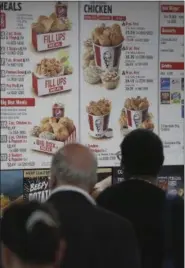  ?? BEBETO MATTHEWS — ASSOCIATED PRESS ?? In this Aug. 24 photo, customers look over a KFC menu labeled with calorie count, in New York City.