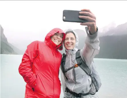  ?? COLLEEN DE NEVE/ CALGARY HERALD ?? Friends Mindy Hamilton, left, and Maura Hamilton from Austin, Texas, stopped to take a selfie of themselves on the shores of Lake Louise while visiting on Thursday. Maura is on a three- week road trip, which is including stops in Lake Louise and Jasper.