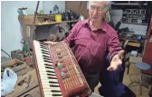  ??  ?? Rosario Scancarell­o displays an accordion he restored inside his shop in Geraci Siculo, a mountainto­p medieval town in the Madonie Mountains in northern Sicily.