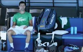  ?? MARK BAKER — THE ASSOCIATED PRESS ?? Defending men’s champion Serbia’s Novak Djokovic rests during a practice session on Margaret Court Arena ahead of the Australian Open tennis championsh­ip in Melbourne, Australia, Thursday.