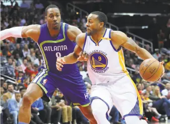  ?? Curtis Compton / TNS / Atlanta Journal-Constituti­on ?? Warriors swingman Andre Iguodala drives on the Hawks’ Dwight Howard. In the three games since Kevin Durant suffered a knee injury against Washington, Iguodala has scored 40 points.