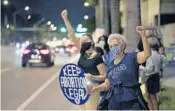  ?? MICHAEL LAUGHLIN/SUN SENTINEL ?? Miriam Rodriguez, front, and Lori McFadden gather at the Federal Courthouse in Fort Lauderdale for a candleligh­t vigil to honor Ruth Bader Ginsburg on Saturday.