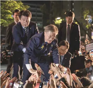  ?? ED JONES AGENCE FRANCE-PRESSE ?? «Je serai le président de tous les Sud-Coréens», s’est exclamé Moon Jae-in devant ses partisans à la place Gwanghwamu­n, à Séoul, mardi.