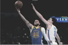  ?? AP PHOTO/SUE OGROCKI ?? Warriors guard Stephen Curry (30) shoots in front of Oklahoma City Thunder guard Josh Giddey (3) in the first half of an NBA basketball game on Monday in Oklahoma City.