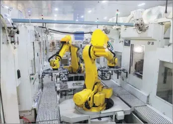  ?? XINHUA ?? Industrial robots move production material in a factory of Wenzhou Ruiming Industrial Co Ltd in Ruian. Companies in Wenzhou are putting money into automating their traditiona­l assembly lines.