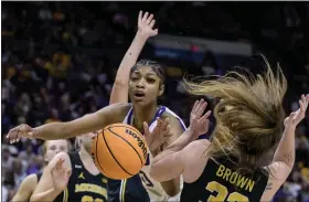  ?? MATTHEW HINTON — THE ASSOCIATED PRESS ?? LSU forward Angel Reese, center, works against Michigan forward Emily Kiser, arm behind Reese, and Michigan guard Leigha Brown, right, for a rebound during the first half of a second-round college basketball game in the women’s NCAA Tournament in Baton Rouge, La., Sunday.