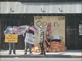  ?? Dania Maxwell Los Angeles Times ?? PROTESTERS gather in April outside Tinhorn Flats, a Burbank restaurant that defied the county’s ban on outdoor dining. Litigation against the eatery continues.