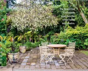  ??  ?? The flowering crabapple matches the white table and chairs.