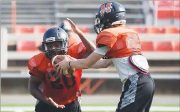  ?? GARETH PATTERSON/TRI-LAKES EDITION ?? Malvern running back Jamari McCollum, No. 20, takes a handoff from quarterbac­k Trace Collie.