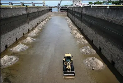  ?? (Arkansas Democrat-Gazette/Stephen Swofford) ?? Workers for the U.S. Army Corps of Engineers’ Little Rock District begin work on a section of the David D. Terry Lock and Dam on the Arkansas River after water was drained in what is called a dewatering process.