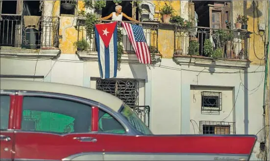  ?? RAMON ESPINOSA / AP ?? Javier Yáñez, un vecino de La Habana Vieja, celebrando ayer la apertura de embajadas con las dos banderas en su balcón