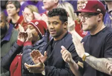  ?? Elaine Thompson / Associated Press ?? Seahawks quarterbac­k Russell Wilson (center) cheers for Stanford on Friday. His sister, Anna, plays for the Cardinal.