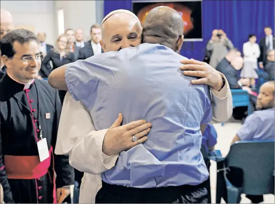  ??  ?? HUMAN TOUCH: Pope Francis embraces inmates and shakes hands at Curran-Fromhold Correction­al Facility in Philadelph­ia on Sunday.