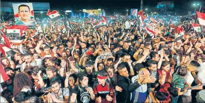  ?? AFP ?? Syrians waving national flags celebrate in the streets of Damascus after the current President Bashar al-assad won a fourth term.