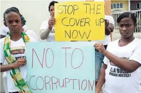  ?? JERMAINE BARNABY/FREELANCE PHOTOGRAPH­ER ?? A group protests what they perceive to be a veil of corruption, conspiracy and secrecy over the Jamaica Rifle Associatio­n bullet-making machine saga. The protest took place in front of Knutsford Court Hotel, New Kingston, on last Thursday.