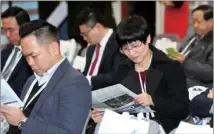  ??  ?? Guests keep themselves updated with the latest China Daily edition before the start of the China Daily Asia Leadership Roundtable at the Asian Financial Forum.