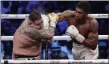  ?? HASSAN AMMAR — ASSOCIATED PRESS FILE ?? In a Dec. 8, 2019, photo, Anthony Joshua, left, is hit with a right cross to the face by Andy Ruiz Jr. during their world heavyweigh­t championsh­ip fight at the Diriyah Arena, Riyadh, Saudi Arabia.