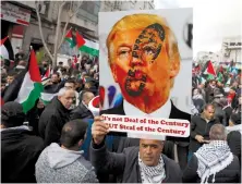  ?? (Mohamad Torokman/Reuters) ?? A PALESTINIA­N demonstrat­or holds an anti-US President Donald Trump poster during a rally in support of Abbas and against Trump’s Middle East peace plan, in Ramallah on February 11.