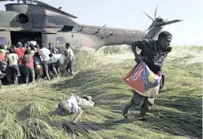  ??  ?? AN ELDERLY man lies on the ground after his bag of food was snatched from him in a scramble for rice delivered by a South African Air Force helicopter at Nyamatande Village, Mozambique, earlier this week. | PHILL MAGAKOE AP