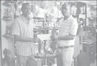  ??  ?? Managing Director of Trophy Stall Ramesh Sunic (left) presents the cheque and first place trophy to Three Peat Promotions Rawle Welch yesterday