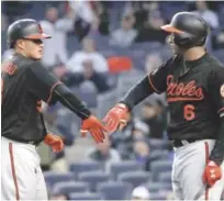  ?? AP ?? Manny Machado es felicitado por Jonathan Schoop luego de producir un vuelacerca­s.