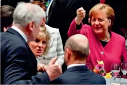  ?? — AFP ?? German Chancellor Angela Merkel jokes with CSU leader and designated German interior minister Horst Seehofer ( L) as German finance minister and vice- chancellor Olaf Scholz of the SPD ( C) watches after the signature of the coalition treaty of the...