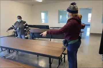  ?? PHOTOS BY JIM SMITH — DAILY DEMOCRAT ?? Volunteers unfold and place tables at the new Beamer Street homeless shelter that is opening in coming days.