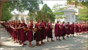  ??  ?? Au monastère de Maha Ganda Yone près de Sagaing, les moines font la queue chaque jour pour recevoir leur nourriture. Ils n’ont pas le droit de cuisiner.