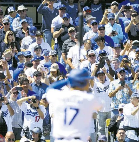  ?? DODGERS Photograph­s by Wally Skalij Los Angeles Times ?? fans grab their cameras to record the first Dodger Stadium at-bat of Shohei Ohtani in blue and white. He doubled but was out trying to take third base.