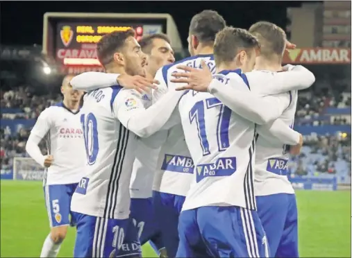  ??  ?? ALEGRÍA ZARAGOCIST­A. Pombo, en medio de la piña de celebració­n, tras marcar el gol que le dio la victoria al Zaragoza.