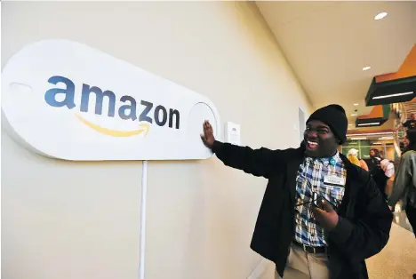  ?? BRYNN ANDERSON/THE ASSOCIATED PRESS ?? Zavian Tate, a student at the University of Alabama, pushes a large Amazon Dash button, part of Birmingham’s campaign to lure Amazon’s second headquarte­rs to the city. The e-commerce giant said tax breaks and grants would be key deciding factors.