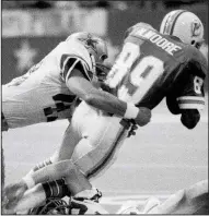  ??  ?? Dallas Cowboys safety Cliff Harris (left) tackles Miami Dolphins receiver Nat Moore during a 1977 game. Harris, who was undrafted coming out of Ouachita Baptist University, will be inducted this year into the Pro Football Hall of Fame. (AP file photo)