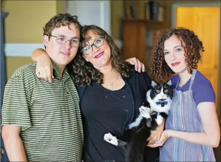  ?? BOB ANDRES /BANDRES@AJC.COM ?? Joshilyn poses for a family portrait with Maisy, Sam and their cat, The Roaches. Family dynamics are often at the heart of her novels.