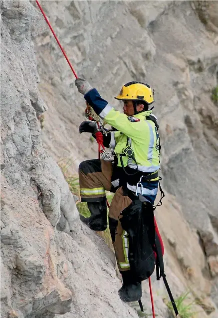  ?? MORGAN WORTHINGTO­N/SUPPLIED ?? Senior firefighte­r John Mahuru ascends the cliff with cat Charlie this January.