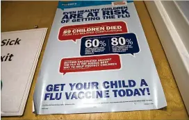  ?? PHOTOS BY ALYSSA POINTER / ALYSSA.POINTER@AJC.COM ?? A poster urges flu shots Wednesday at Conyers Pediatrics. Experts stress that, even if you get the flu, the vaccine can lessen its severity.