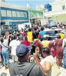  ?? HOPETON BUCKNOR ?? A large crowd gathers near the scene while the two men who shot each other following a dispute caused by a road crash were being rushed to hospital.