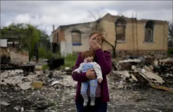  ?? Natacha Pisarenko/Associated Press ?? Nila Zelinska holds a doll belonging to her granddaugh­ter Tuesday. She was able to find the doll in her destroyed house in Potashnya on the outskirts Kyiv, Ukraine. Ms. Zelinska just returned to her hometown after escaping war to find out she is homeless.