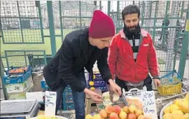  ?? Ramin Mostaghim For The Times ?? ALI JAFARI, right, a married father of two, earns about $750 a month from his fruit stall at a weekly market in west Tehran. “How else could I survive?” he said.