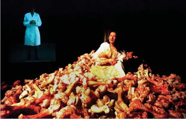  ?? Foto: Reuters ?? Marina Abramovic auf Tierknoche­n sitzend während ihrer Performanc­e »Balkan Baroque« auf der 47. Biennale in Venedig (1997).