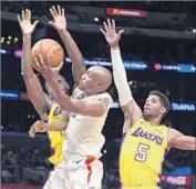  ?? Kelvin Kuo Associated Press ?? CLIPPERS GUARD C.J. Williams goes up for a shot between Lakers Josh Hart (5) and Julius Randle.
