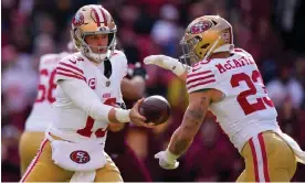  ?? Commanders. Photograph: Alex Brandon/AP ?? San Francisco 49ers quarterbac­k Brock Purdy (13) hands the ball off to running back Christian McCaffrey (23) during the first half of Sunday’s game against the Washington