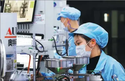  ?? XU CHANGLIANG / FOR CHINA DAILY ?? Employees work on a production line for export-bound electronic devices in Suqian, Jiangsu province, on Feb 7.