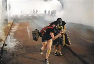  ?? Nathan Howard Getty Images ?? WHEN PROTESTS against racism and police brutality persisted well into the summer in Portland, Ore., the Trump administra­tion sent in federal officers. Nightly clashes ensued.