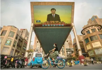  ?? MARK SCHIEFELBE­IN/AP ?? The image of Chinese President Xi Jinping looms Friday from a screen in Beijing broadcasti­ng state television news coverage of his visit to Hong Kong. Xi marked the 25th anniversar­y of Hong Kong’s return with a speech countering criticism that political and civic freedoms in the former British colony have been largely erased under Chinese rule.