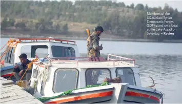  ?? — Reuters ?? Members of the US-backed Syrian Democratic Forces (SDF) stand on a boat at the Lake Assad on Saturday.