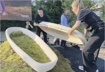  ?? AP ?? Director Lonneke Westhoff, right, and founder Bob Hendrikx, left, of Loop Biotech display one of their coffins grown from local mushrooms and upcycled hemp fibres, in Delft, Netherland­s.