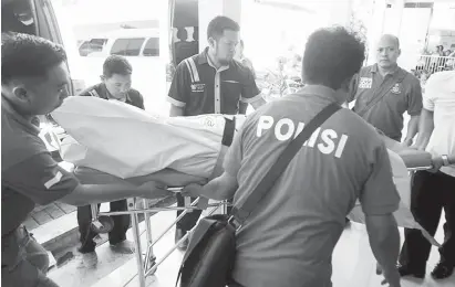  ?? (AP) ?? INDONESIA. Police officers carry a body bag containing one of the victims of Sunday's explosions upon arrival at a hospital in Surabaya, East Java, Indonesia, Monday, May 14, 2018.