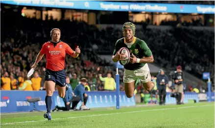  ?? GETTY IMAGES ?? South Africa’s Kurt-Lee Arendse goes over to score his side’s first try against England in London, while, at left, South African prop Thomas du Toit is shown a red card after he shoulder-charged the head of England’s Luke Cowan-Dickie.